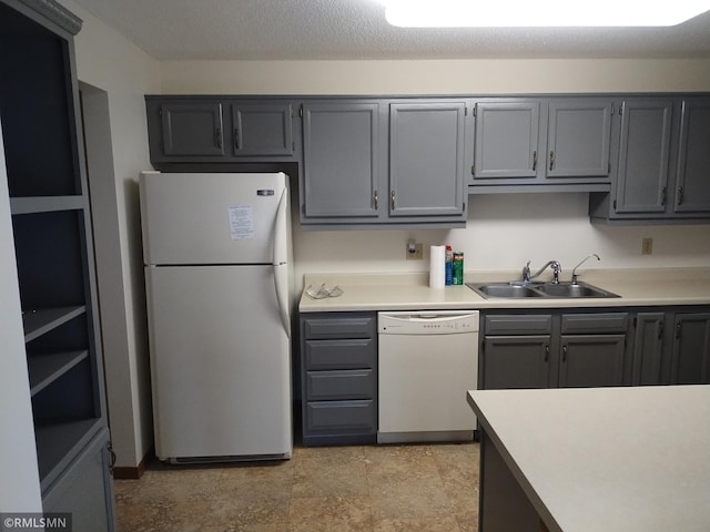 kitchen featuring white appliances, gray cabinets, and sink