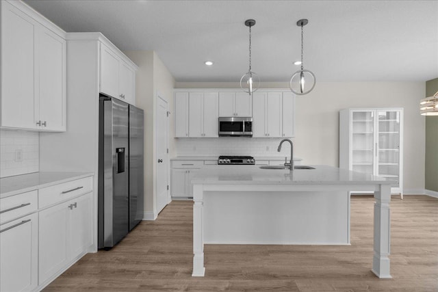 kitchen with white cabinets, tasteful backsplash, appliances with stainless steel finishes, and a sink