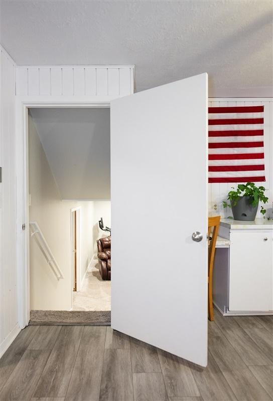 corridor featuring a textured ceiling and hardwood / wood-style flooring