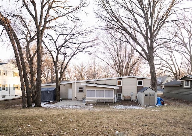 rear view of house featuring a patio area and a storage shed