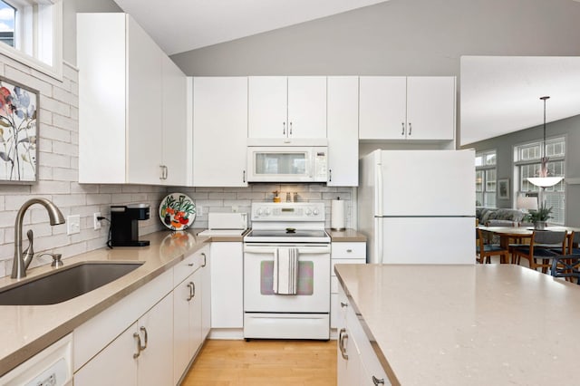 kitchen featuring white cabinetry, sink, and white appliances