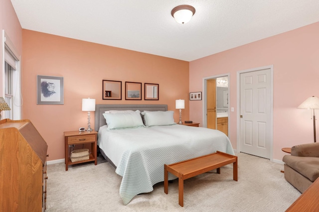 bedroom featuring connected bathroom and light carpet