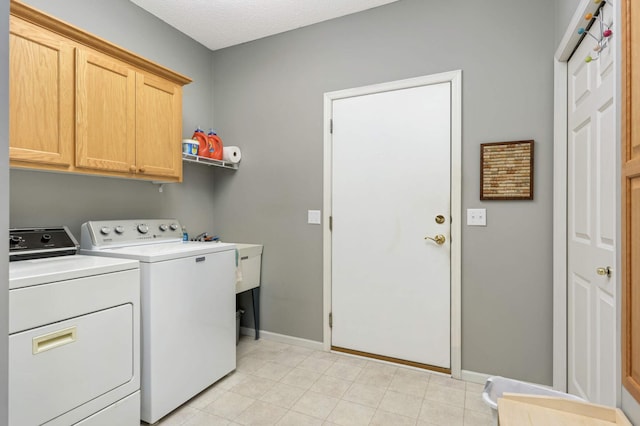 washroom with cabinets and washing machine and clothes dryer