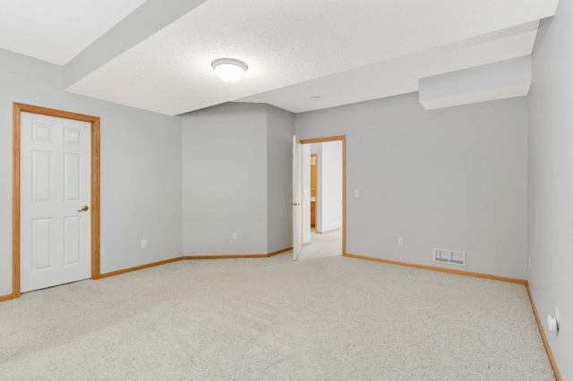 carpeted spare room with a textured ceiling