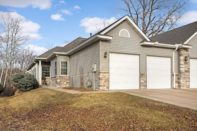 view of side of property featuring a garage and a lawn