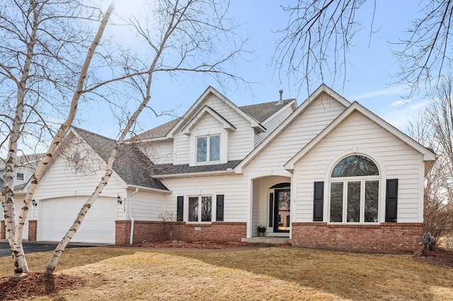 view of front facade with brick siding, driveway, an attached garage, and a shingled roof