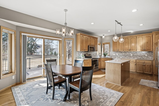 dining room with an inviting chandelier, light wood-style flooring, recessed lighting, and baseboards