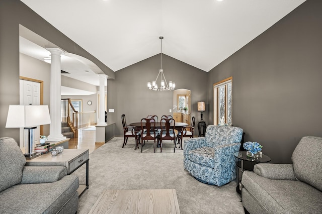 carpeted living area with stairway, arched walkways, decorative columns, a chandelier, and vaulted ceiling