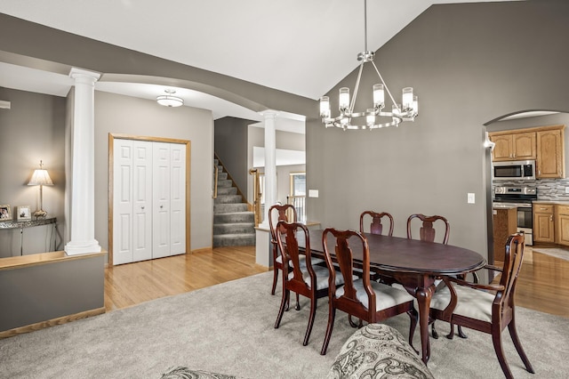 dining space with stairway, light wood finished floors, ornate columns, and light carpet