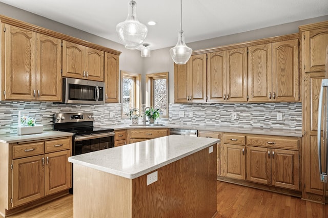 kitchen featuring decorative backsplash, stainless steel appliances, light wood-style floors, and a sink