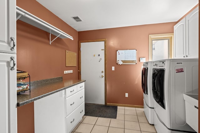 laundry area featuring visible vents, independent washer and dryer, cabinet space, light tile patterned floors, and baseboards