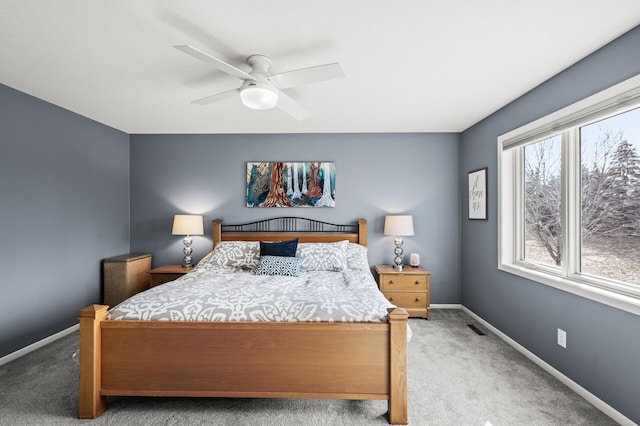 carpeted bedroom featuring a ceiling fan, visible vents, and baseboards