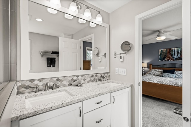 ensuite bathroom with double vanity, tasteful backsplash, ensuite bathroom, and a sink