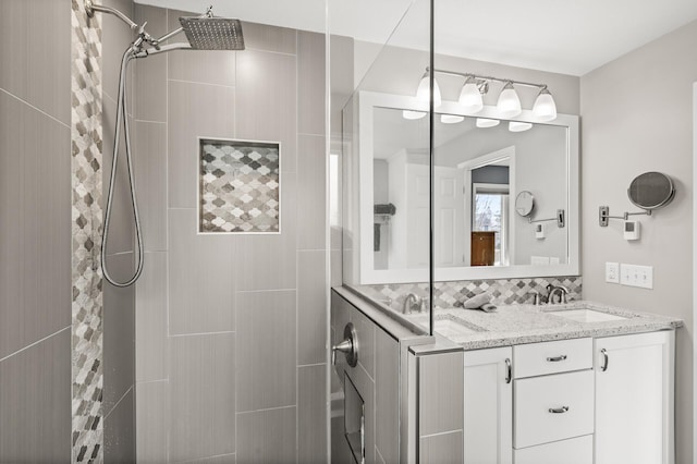 full bath featuring vanity and tiled shower