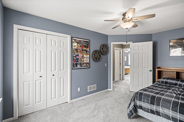 carpeted bedroom featuring visible vents, baseboards, a closet, and ceiling fan