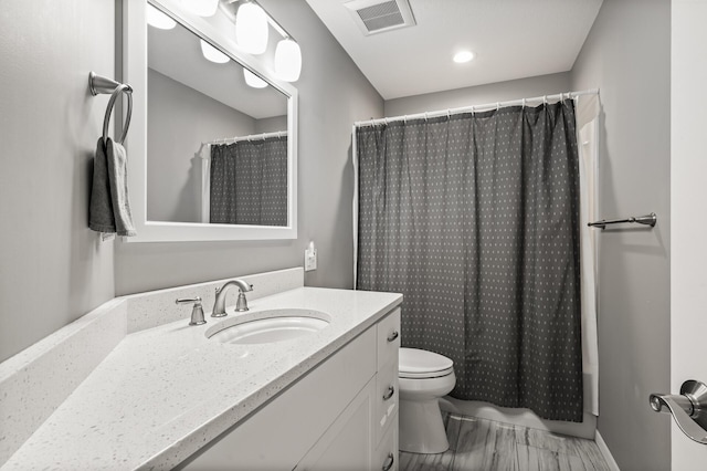 full bathroom with visible vents, toilet, curtained shower, wood finished floors, and vanity