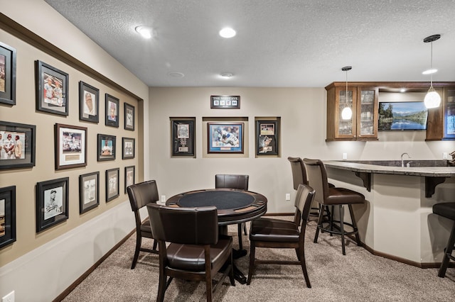 dining room with baseboards, a textured ceiling, and carpet