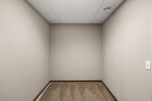 empty room featuring carpet flooring, baseboards, and a drop ceiling