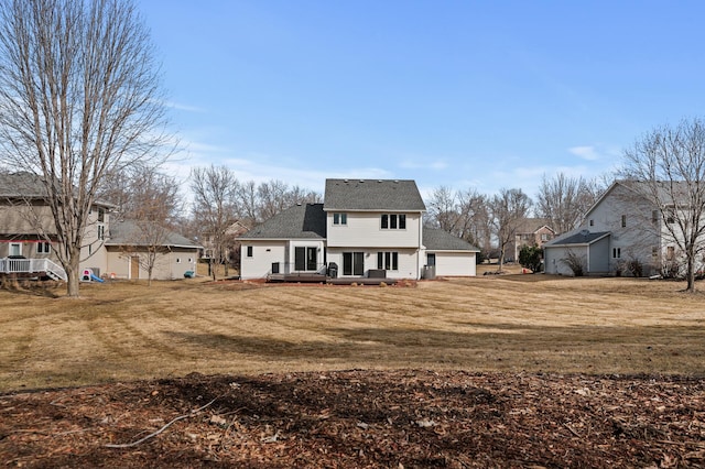 back of house with a deck, a yard, and a shingled roof