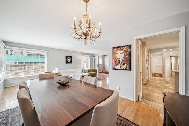 dining room featuring a barn door and light hardwood / wood-style flooring