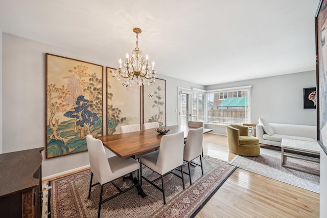 dining space with a notable chandelier and hardwood / wood-style floors