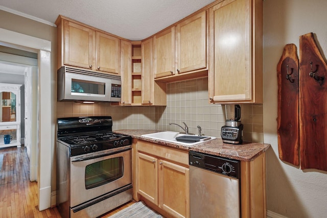 kitchen featuring light brown cabinetry, light stone counters, sink, and appliances with stainless steel finishes