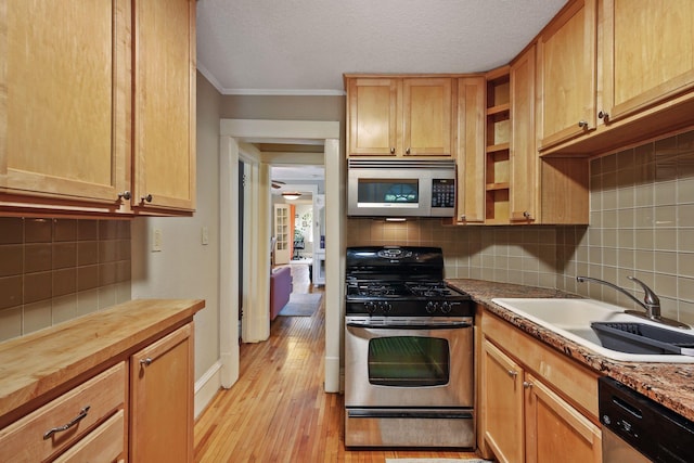 kitchen featuring sink, light stone counters, light hardwood / wood-style flooring, crown molding, and appliances with stainless steel finishes