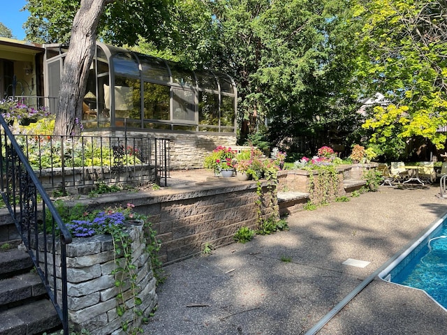 view of swimming pool with a patio area and a sunroom