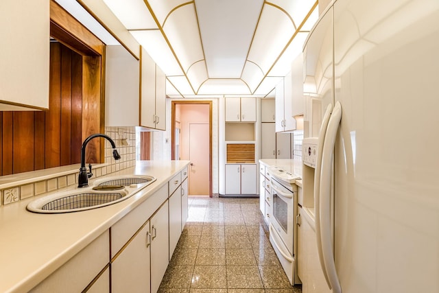 kitchen with white cabinetry, white appliances, and sink