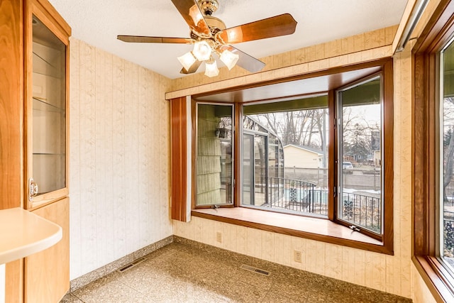 interior space with ceiling fan