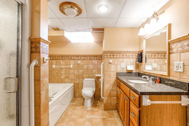 full bathroom with vanity, a paneled ceiling, tile walls, and tile patterned flooring