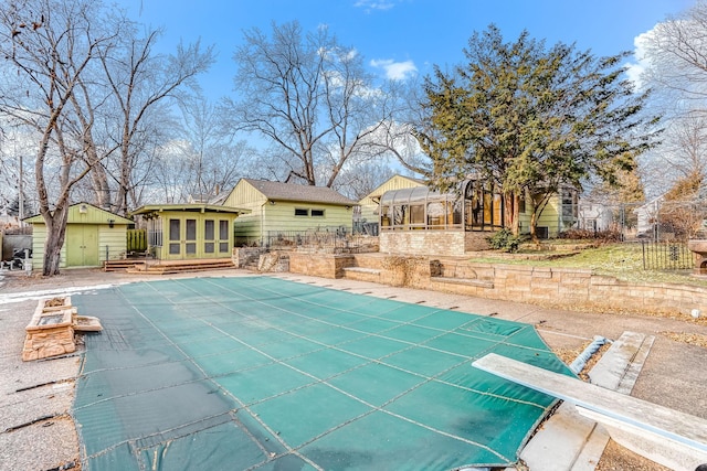 view of pool with a diving board and a storage unit