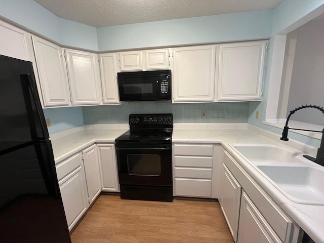 kitchen with white cabinets, sink, and black appliances