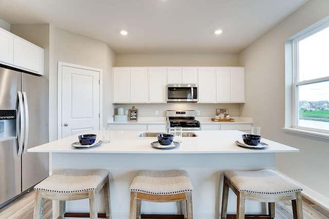 kitchen featuring appliances with stainless steel finishes, a breakfast bar area, and white cabinetry