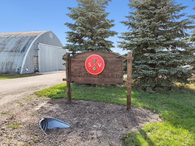 community / neighborhood sign with dirt driveway