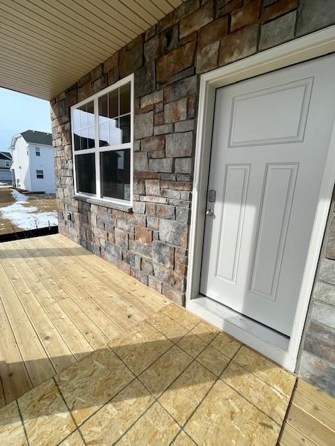 property entrance with stone siding and covered porch