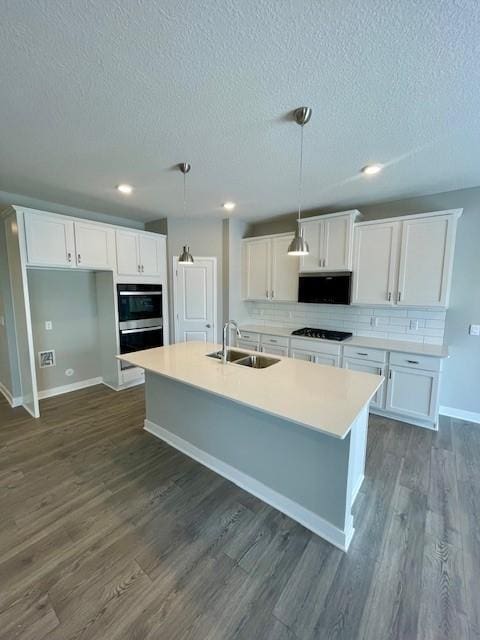 kitchen with black gas cooktop, white cabinetry, dark wood-style flooring, and a sink