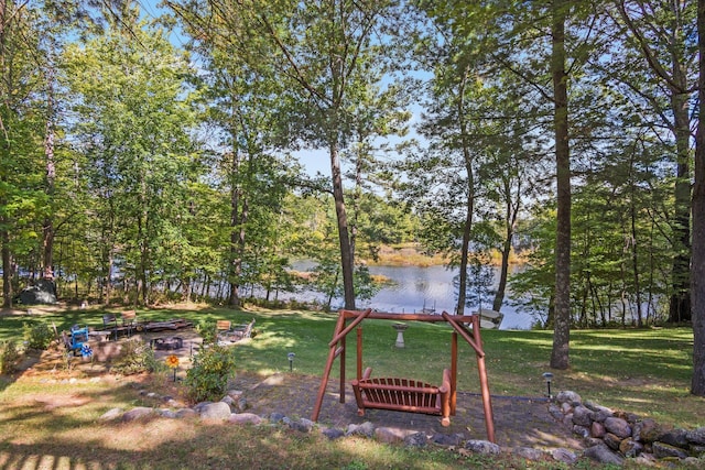 view of yard with a fire pit and a water view