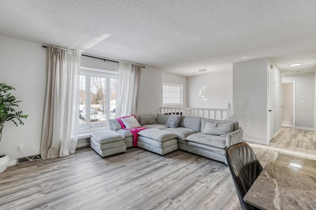 living room featuring light hardwood / wood-style floors and a textured ceiling