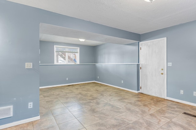 unfurnished room with a textured ceiling