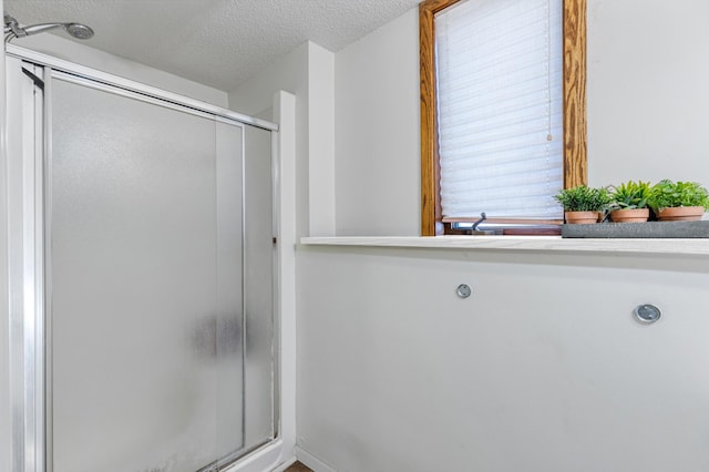 bathroom featuring a textured ceiling and walk in shower