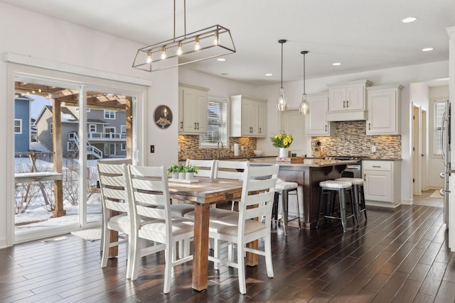 dining area with dark wood-type flooring and recessed lighting