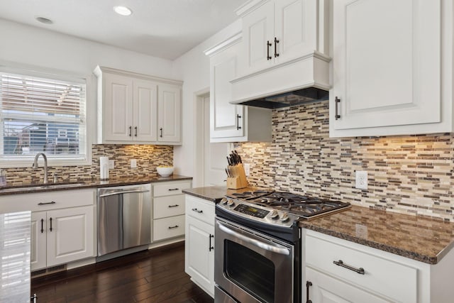 kitchen with tasteful backsplash, dark wood finished floors, appliances with stainless steel finishes, white cabinetry, and a sink