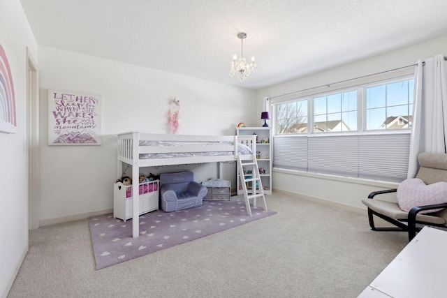 carpeted bedroom featuring a textured ceiling, baseboards, and an inviting chandelier