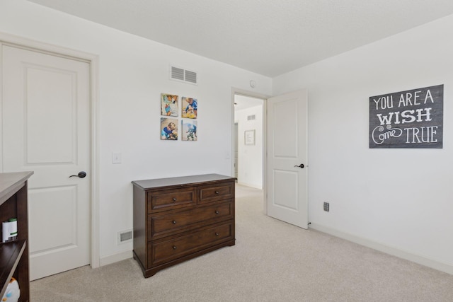 bedroom with visible vents, light carpet, and baseboards