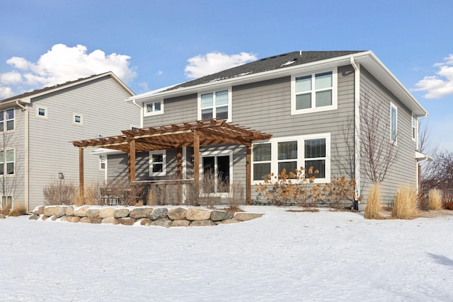 snow covered rear of property featuring a pergola