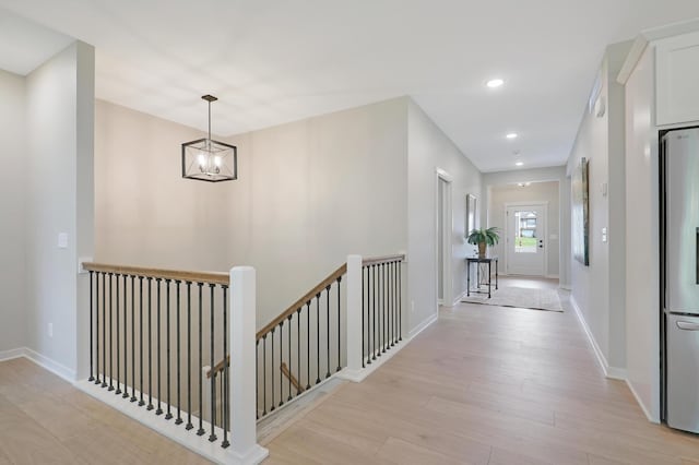 hall featuring light hardwood / wood-style flooring and a notable chandelier