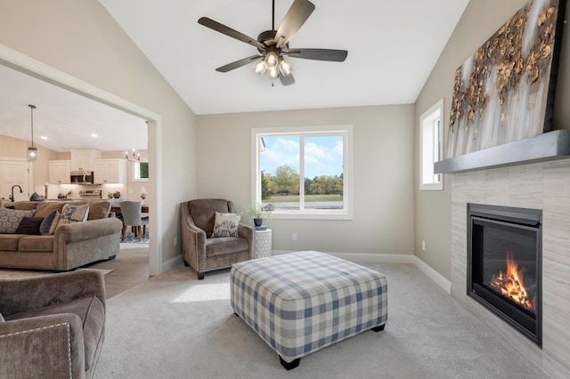 living room with a tile fireplace, ceiling fan, plenty of natural light, and lofted ceiling