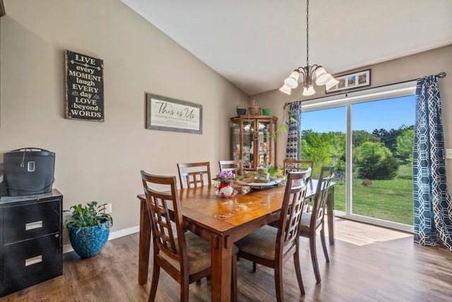 dining area featuring wood finished floors, a chandelier, vaulted ceiling, and baseboards