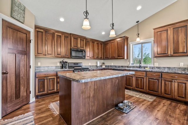 kitchen featuring black microwave, stainless steel gas range, lofted ceiling, dark wood finished floors, and hanging light fixtures